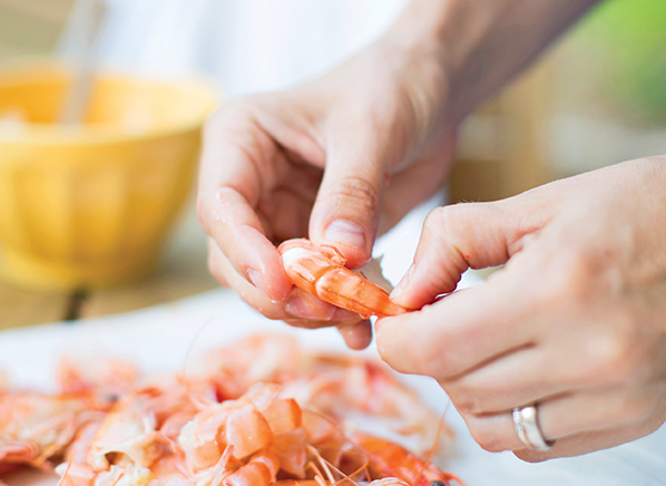 Woman's hands cleaning prawns 